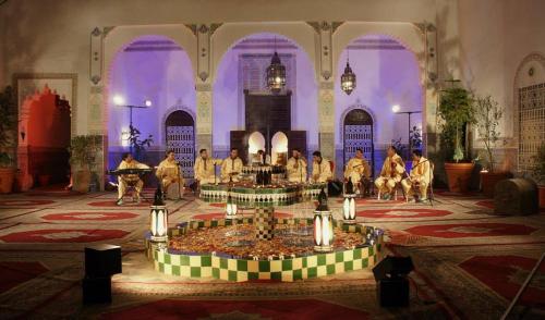 un gruppo di persone che suonano in una stanza con una fontana di Riad Freija-TAROUDANT a Sidi Abd el Kader