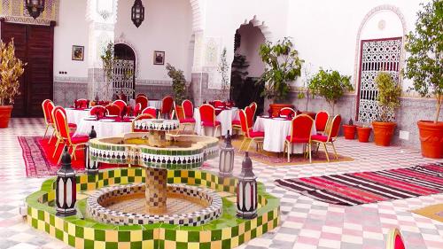 un ristorante con sedie rosse e tavoli in un edificio di Riad Freija-TAROUDANT a Sidi Abd el Kader