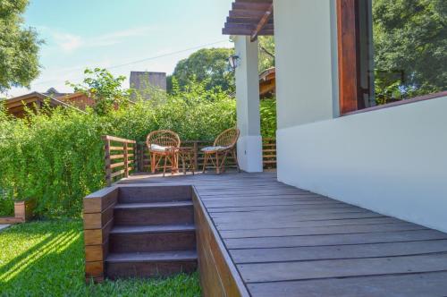 a wooden deck with two chairs and a table at Excelente casa en Concepción del Uruguay LA CHINA in Concepción del Uruguay
