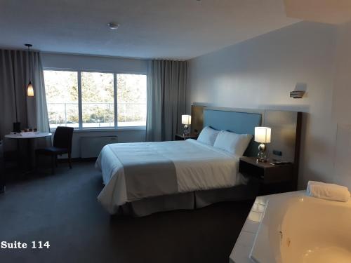 a hotel room with a large bed and a bathroom at Auberge Matha in Saint-Jean-de-Matha