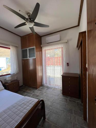 a bedroom with a bed and a ceiling fan at Villa Christina 2 in Mérikhas