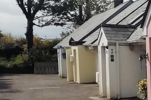 een rij witte gebouwen op een parkeerplaats bij Bovinda Cottage - By the Beach, Bettystown in Bettystown