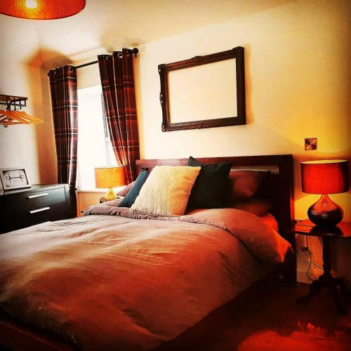 a bedroom with a bed with a mirror on the wall at Bryansford Cottage Stables in Bryansford