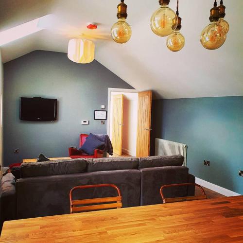 a living room with a couch and a table at Bryansford Cottage Stables in Bryansford