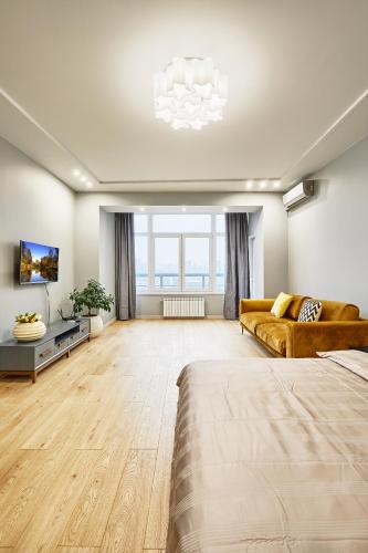 a large living room with a couch and a tv at Botanic Towers the house has a shelter in Kyiv