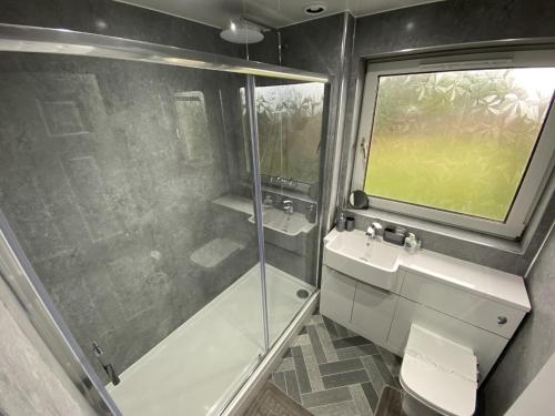 a bathroom with a shower and a toilet and a sink at Pure Apartments Fife - Dunfermline - Pitcorthie in Dunfermline