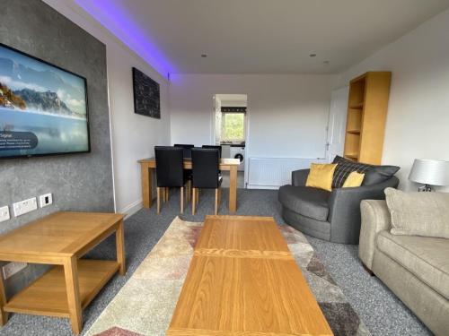 a living room with a couch and a table at Pure Apartments Fife - Dunfermline - Pitcorthie in Dunfermline