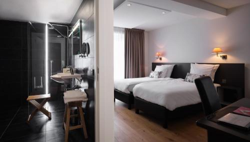 A bed or beds in a room at Le 24 Hotel