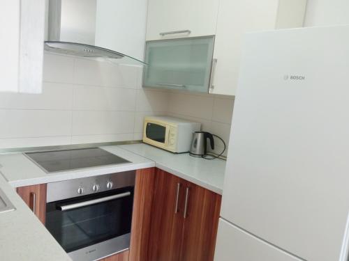 a small kitchen with a microwave and a stove at Great apartment, free parking in the garage, Žnjan in Split