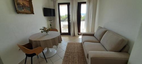 a living room with a couch and a table at Apartmani Dragovic in Brodarica