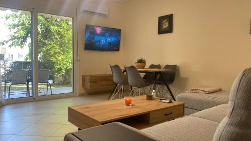 salon z kanapą i stołem w obiekcie Elena apartment chalkidiki w mieście Kallithea