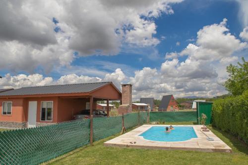 una piscina nel cortile di una casa di Cabañas Las Achiras a Sierra de la Ventana