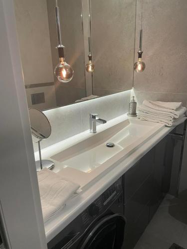 W łazience znajduje się biała umywalka i lustro. w obiekcie APARTAMENT Poniatowa w mieście Poniatowa