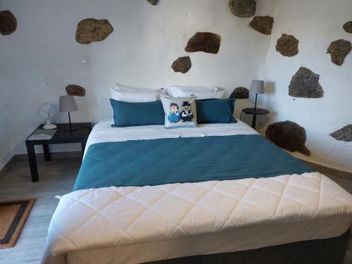 a bedroom with a bed with rocks on the wall at Quinta da Ponte in Viana do Castelo