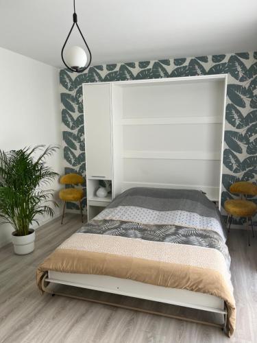 une chambre avec un lit et deux chaises dans l'établissement Un havre de paix en plein coeur de ville près Chu, à Clermont-Ferrand