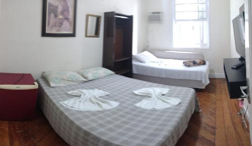 a room with two beds with towels on them at Casa da Praia in Santos