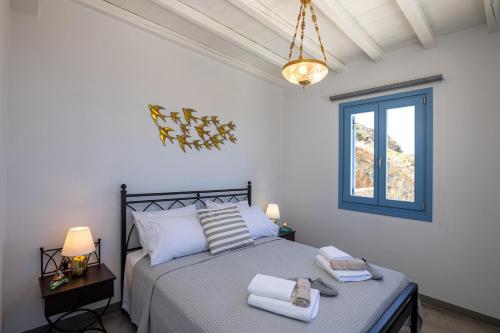 sypialnia z łóżkiem i oknem w obiekcie Aegean Muses w mieście Arnados