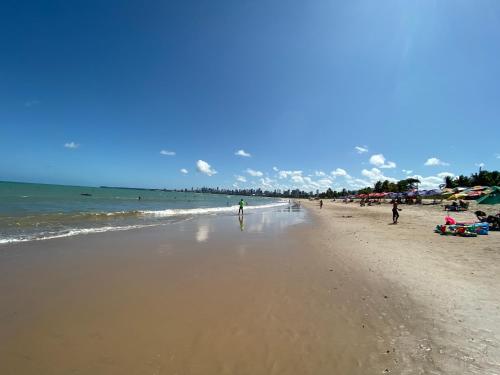 a group of people walking on the beach at Mardisa Design by Jess Hospedagens in João Pessoa