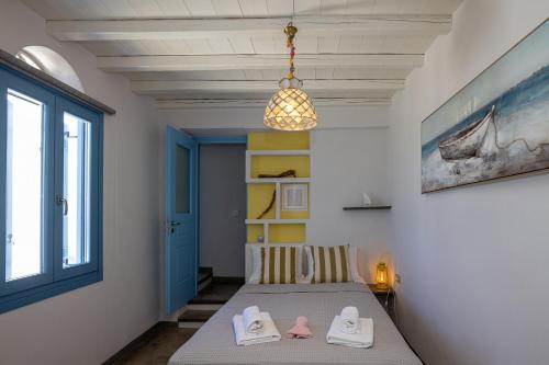 a bedroom with a bed with two slippers on it at Aegean Muses in Arnados
