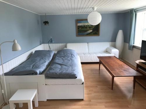 een woonkamer met een witte bank en een tafel bij Sommerhus på Mors in Øster Assels