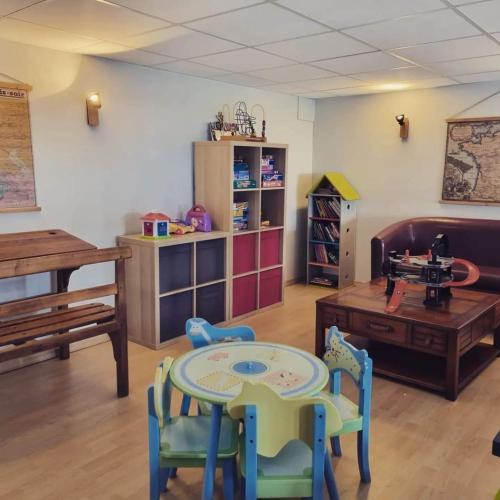 a living room with a table and chairs and a table at Hôtel Les Charmilles in Besse-et-Saint-Anastaise
