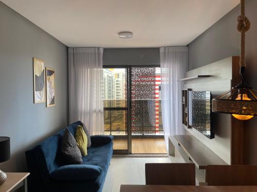 a living room with a blue couch and a window at Mardisa Design by Jess Hospedagens in João Pessoa