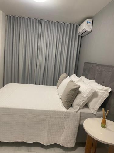 a bedroom with a bed with white sheets and pillows at Mardisa Design by Jess Hospedagens in João Pessoa