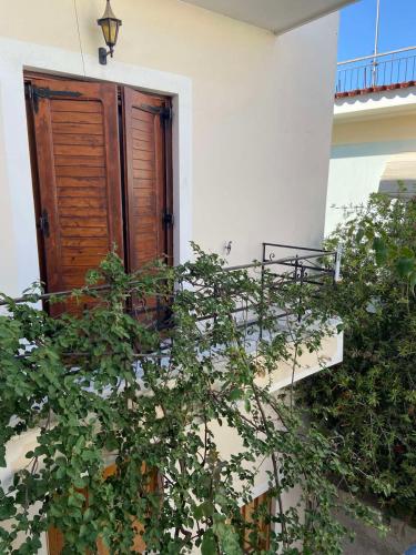 a building with a wooden door and some plants at Filoxenia Apartments in Mytilini