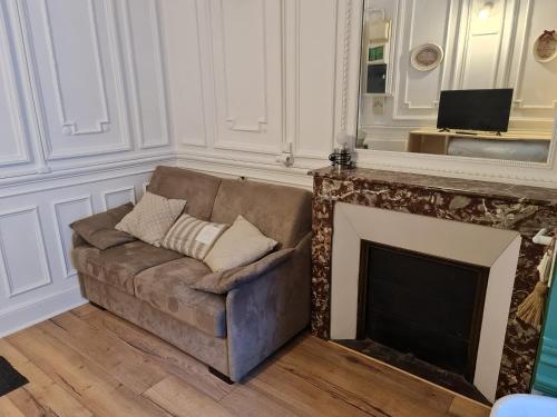 - un canapé dans le salon avec cheminée dans l'établissement LE SARCIRON, à Le Mont-Dore