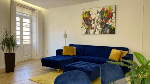 a living room with a blue couch and yellow pillows at FERREIRA'S HOUSE Guimarães in Guimarães
