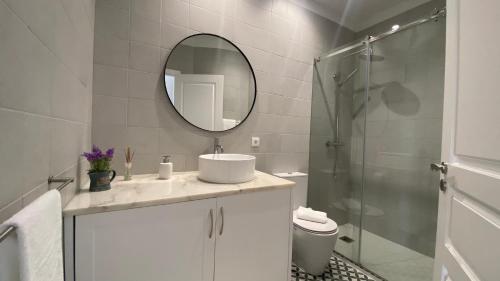 bagno bianco con lavandino e specchio di FERREIRA'S HOUSE Viana do Castelo a Viana do Castelo