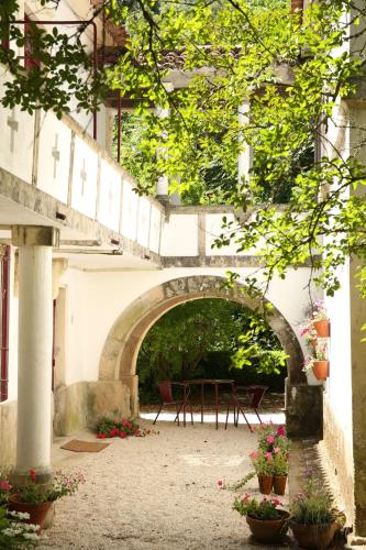 an archway in a building with a table and flowers at Casa Agricola da Levada Eco Village in Vila Real