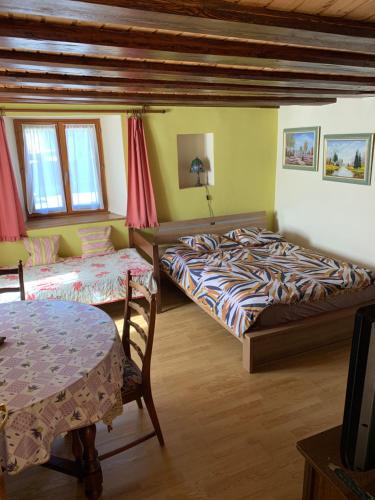 ein Schlafzimmer mit zwei Betten und einem Tisch in der Unterkunft Appartement Style Rustique in Urbès