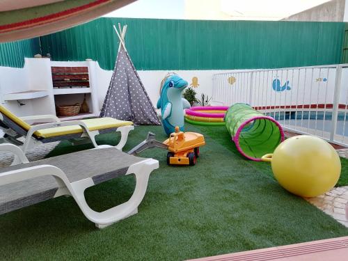 ein Spielzimmer mit grünem Gras und einem Spielplatz in der Unterkunft Marreiro's house Algarve - Child friendy - Private Pool in Lagos