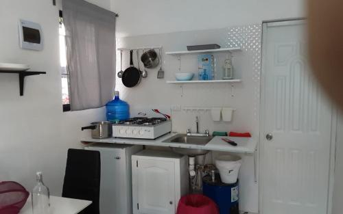 a small kitchen with a sink and a stove at Vilaa Colonial Suite N 7, Basic exterior in Río San Juan