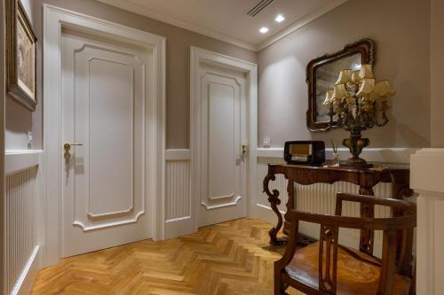a hallway with a table and a mirror and a chair at Luxury B&B Villetta Carra City - Gallipoli in Gallipoli
