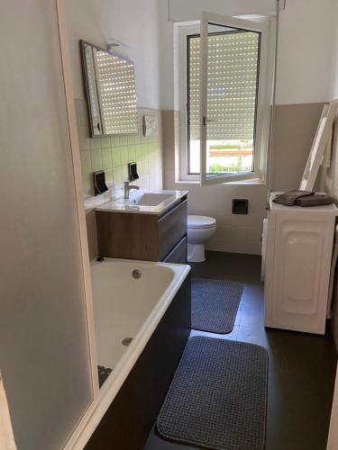 a bathroom with a tub and a sink and a toilet at Casa Bosco in Levico Terme