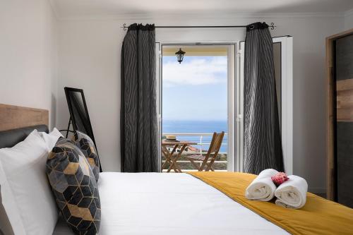a bedroom with a bed and a view of the ocean at UP THE HILL, Conforto e bem estar in Ponta do Sol
