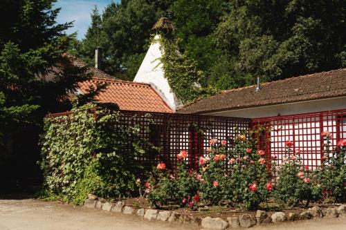 a fence with flowers in front of a house at Casa Agricola da Levada Eco Village in Vila Real