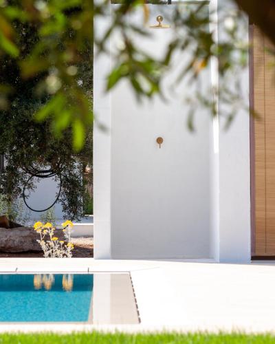 a door to a house with a pool and flowers at Le Dimore Di Speziale in Fasano