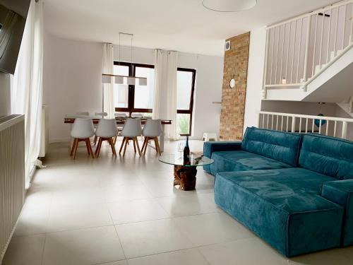 un salon avec un canapé bleu et une table dans l'établissement Baltica Heaven - Apartament dwupoziomowy przy plaży, à Rogowo