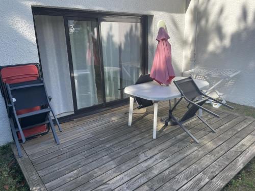 a deck with a table and chairs and a lamp at VVF Résidence Anglet in Anglet