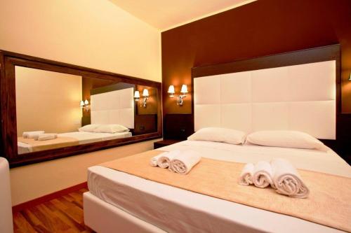 a bedroom with two beds and a large mirror at Momi's Hotel in Cavarzere