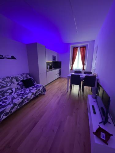 Habitación púrpura con cama y mesa con sillas en Cavour Home, en Roma
