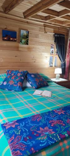 a bedroom with a bed with blue sheets and pillows at El Pedregal Sopó in Sopó