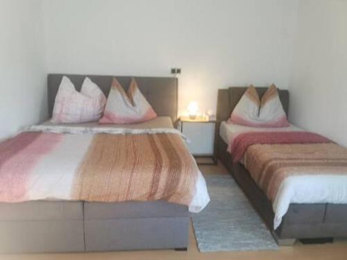 1 dormitorio con 2 camas y almohadas rojas y blancas en Apartments in der Nähe von Red Bull Ring en Proleb