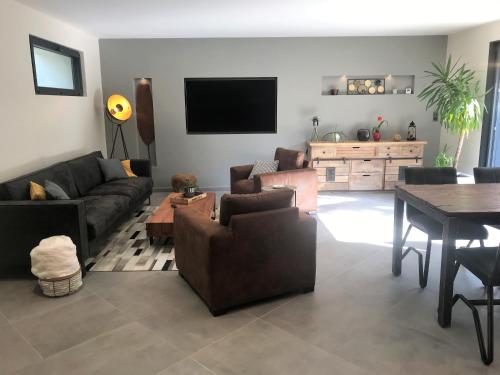 a living room with a couch and a table at Gite de la Prée SPA luxe proche Giverny et bord de l'Eure in Ménilles