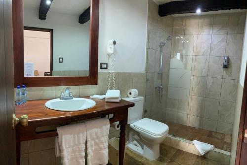 a bathroom with a toilet and a sink and a shower at Villa Colonial in Antigua Guatemala