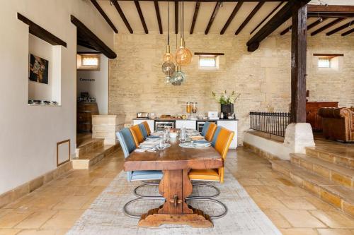 a dining room with a wooden table and chairs at L'Ecurie Gourmande in Thaon