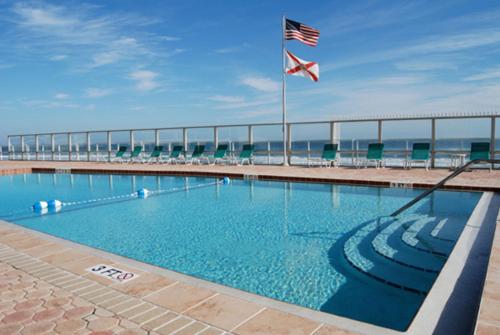 a large swimming pool with an american flag in front of the ocean at Shores Club 703 in Daytona Beach